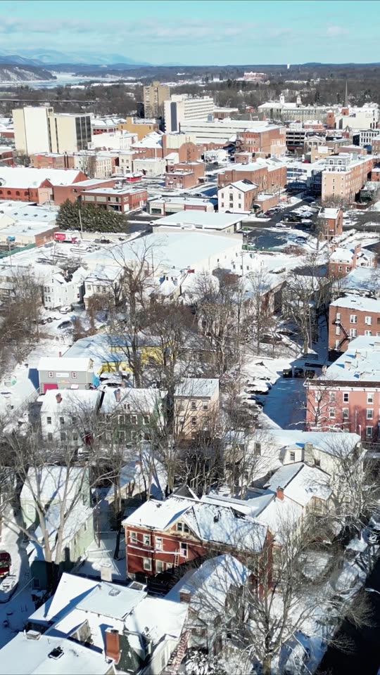 Ascending over downtown Poughkeepsie in winter (vert)